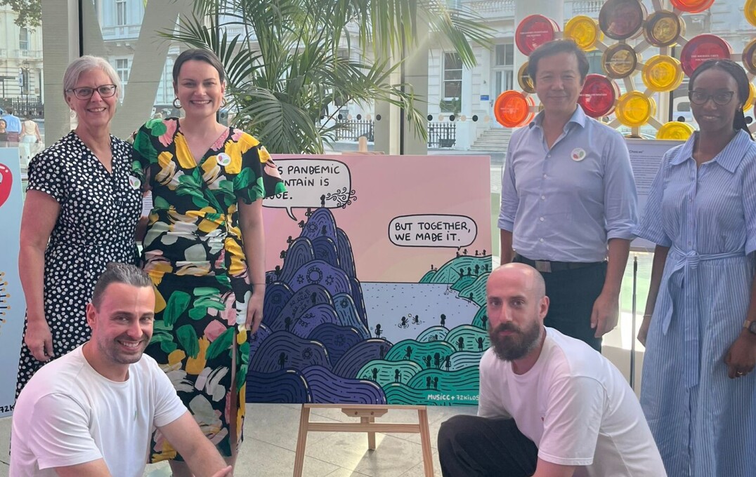 Members of the MUSICC coordination team gather around the artwork 'Over the Mountain' by artist 72kilos.