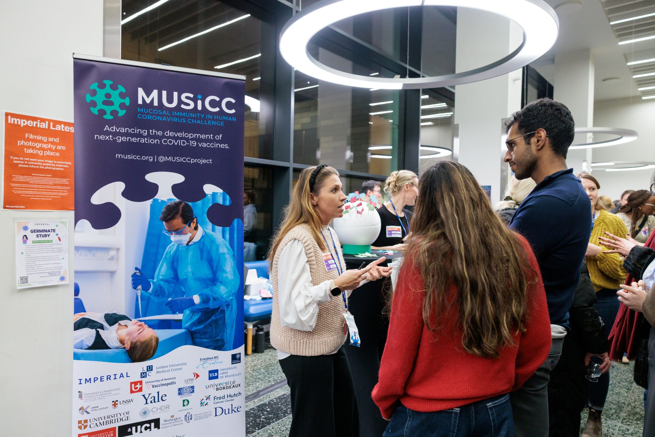 Photograph of MUSICC staff in conversation with members of the public at the Would You Get Sick for Science stand.